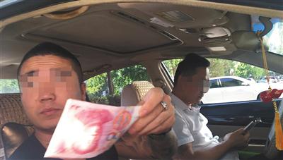 号贩子隔着车窗给一名兼职人员100元作为报酬。 